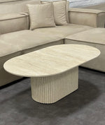 Table basse en travertin Sabbia avec plateau ovale et pied central strié, design artisanal élégant et intemporel.