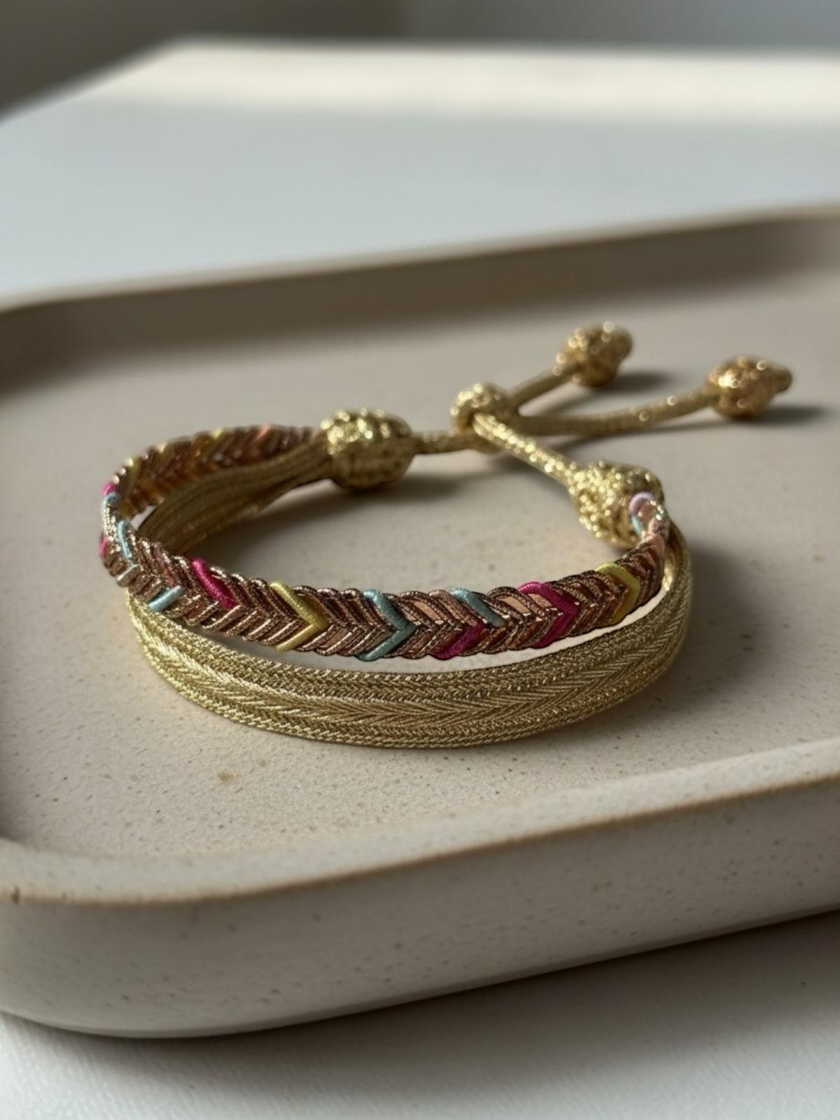 Bracelet en passementerie multicolore & or, motif chevron, fait main au Maroc. Tressage Sfifa, 50% soie / 50% fil d’or. Ruban tressé avec cordon coulissant et embouts décoratifs, dominante rose soutenu.