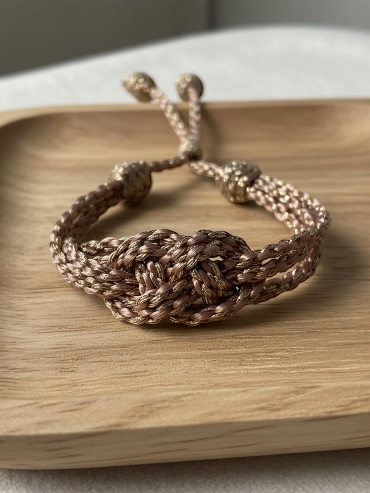 Bracelet en passementerie champagne rosé avec reflets dorés, tressage Sfifa, fait main au Maroc en 50% soie et 50% fil à effet or, fermoirs décoratifs visibles.