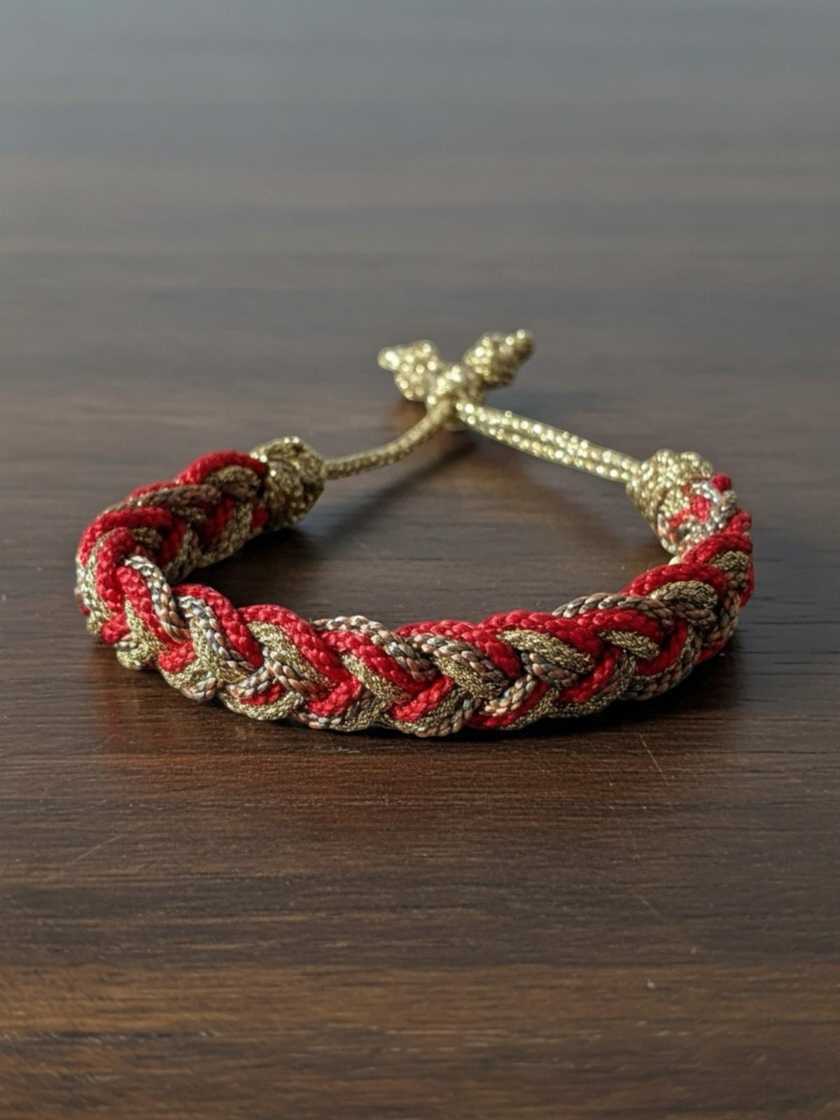 Bracelet en passementerie rouge et or, inspiré des cafetans marocains, fait main avec 50% fil de soie et 50% fil d'or, alliant tradition et haute couture artisanale marocaine.