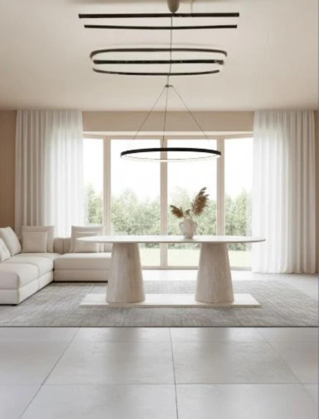 Table à manger ovale Elyana en travertin naturel beige, avec deux pieds cylindriques massifs – design minimaliste haut de gamme
